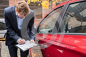 Insurance Agent Examining Car After Accident