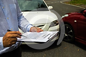The insurance agent examining car after accident on the road. In