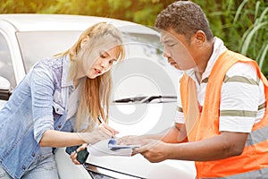 The insurance agent inspects the damaged vehicle and The customer signs the filing of the post-accident claim report form.
