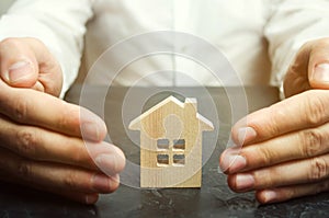 Insurance agent protects the house with a gesture of protection. The concept of property insurance protection and housing.