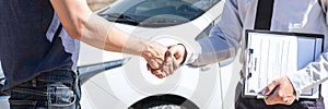 Insurance agent shaking hands client after examine the damage of the car after accident on report claim form process