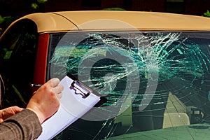 Insurance agent writing on clipboard, report car accident