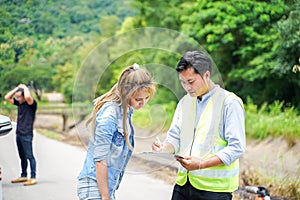 The insurance agent writing the details on the claim report form after the accident.