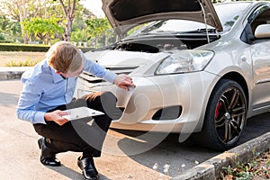 Insurance agent writing document on clipboard examining car after accident, Insurance concept