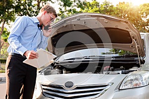 Insurance agent writing document on clipboard examining car after accident, Insurance concept