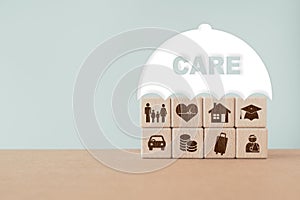 Insurance, assurance concept. Family, heart, house, hat, car, coin, luggage, injured person icon on wooden background under