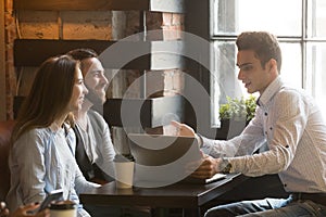 Insurance broker or salesman making offer to couple in cafe