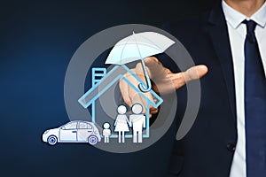 Insurance concept - umbrella demonstrating protection. Man using virtual screen with illustrations