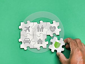 Insurance coverage concept with icons and hand on jigsaw puzzle pieces