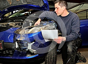 Insurance expert working at damaged car