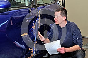 Insurance expert working at damaged car