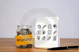 Insurance financial. Mason jar with coins inside, written budget Empty notebook with pen, icon healthcare medical