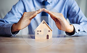 Insurance house, and family health live concept. The insurance agent presents  the hands protection model that symbolize the cover