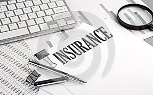 INSURANCE text on paper with chart and keyboard, business concept