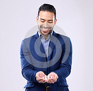 Insurance, trust and financial security with a business man holding a paper cutout of a family on a studio gray