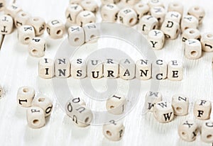 Insurance word written on wood block.