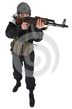 Insurgent dressed in black uniform and black and white shemagh with AK 47 rifle photo