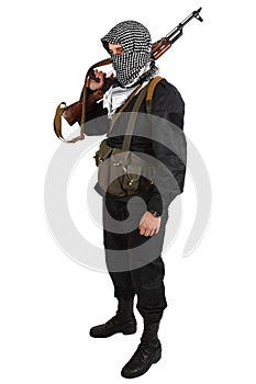 Insurgent dressed in black uniform and black and white shemagh with AK 47 rifle photo