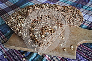 homemade Integral black brown bread on  wood kitchen board photo