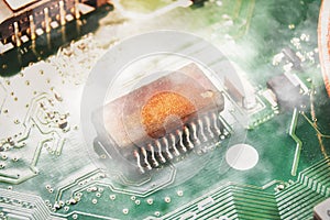 Integrated circuit IC burns and smoke on the electronic circuit board of the computer laptop