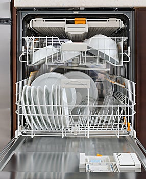 Integrated dishwasher with dishware in a kitchen. Home appliances