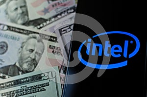 Intel logo on a smartphone and money. Concept for profit