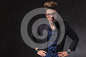 Inteligent handsome man wearing glasses pose in dark studio with