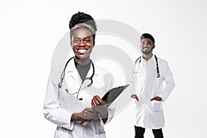 Intellectual healthcare professional afro american doctor with collegue with clipboard isolated on white background