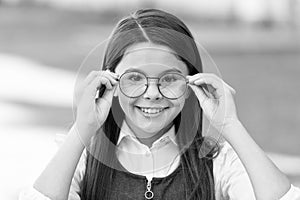 An intellectual look. Happy child look through glasses outdoors. Vision screening at school. Eye test. Corrective