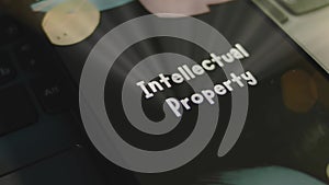 Intellectual Property inscription on smartphone screen. Graphic presentation on black background with bokeh lights