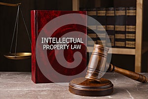 Intellectual Property law book and judge`s gavel on grey marble table