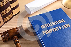 Intellectual Property law book and judge`s gavel on wooden table