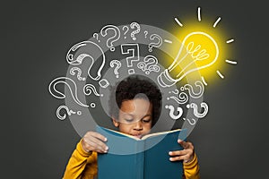 Intelligent black kid student reading book and having idea. Brainstorming and idea concept