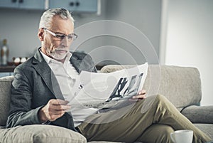 Intelligent businessman reading daily newspaper