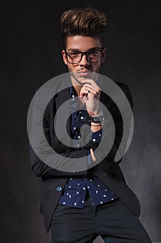 Intelligent guy wearing glasses pose seated and thinking