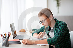 Intelligent schooler working hard on homework, online education