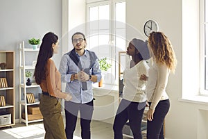 Group of young diverse business people or colleagues talking in informal office meeting photo