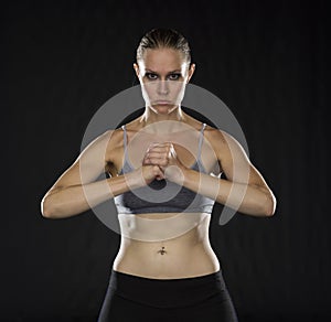 Intense Athletic Woman Holding Fist in Studio