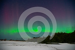 Intense northern lights aurora borealis over beach in Latvia