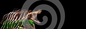 Intensity of training session. Muscular, shirtless man in motion, running against black background with stroboscope