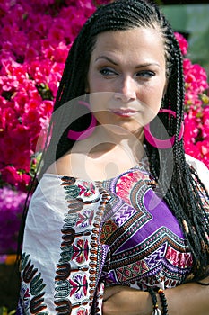 Intent look of beautiful blue - eyed woman with the african pigtails