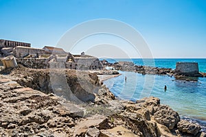 Intentional blurred stones on cliff by the sea and with walls of the fort of the island of Las Palomas, Tarifa SPAIN photo