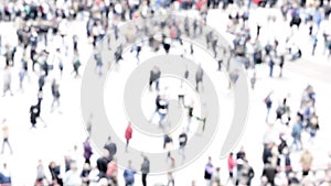 Intentionally blurred abstract aerial  image of crowd of unrecognizable people walking in the city.