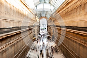 Intentionally motion blurred creative image of people and commuters walking in Galleria Vittorio Emanuele II in Milan, Italy