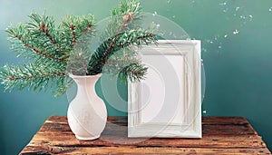 inter still life. Horizontal white frame mockup on vintage wooden bench, table. Modern white ceramic vase with pine tree branches