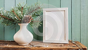 inter still life. Horizontal white frame mockup on vintage wooden bench, table. Modern white ceramic vase with pine tree branches