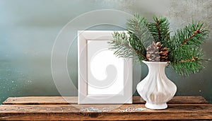 inter still life. Horizontal white frame mockup on vintage wooden bench, table. Modern white ceramic vase with pine tree branches