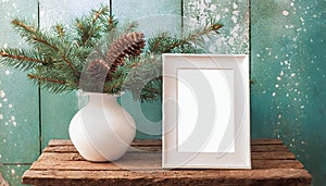 inter still life. Horizontal white frame mockup on vintage wooden bench, table. Modern white ceramic vase with pine tree branches