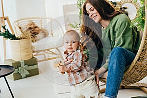 Interaction between an active toddler and a young mother at home. Spending time together.