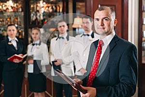 The interaction of the staff. Hotel or restaurant manager and his staff in kitchen. interacting to head chef in